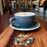 A latte and spices on a wood table at Lift Bridge Coffee